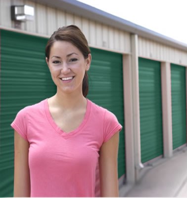A Smiling Woman Stands In Front Of A Self Storage Facility
