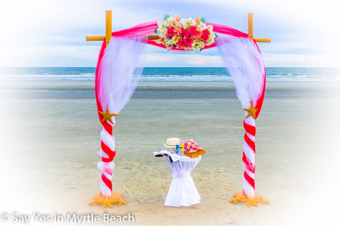 Red and white tulle wrapped arbor